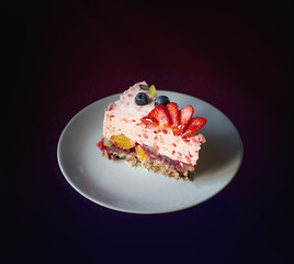Piece of jelly fruit cake with milk on a white plate