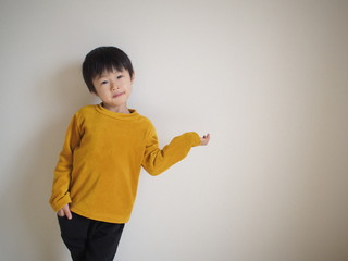 「こちらです」ポーズをする子供