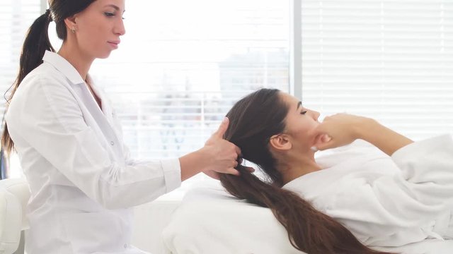 Beautiful young girl having face massage in spa salon.