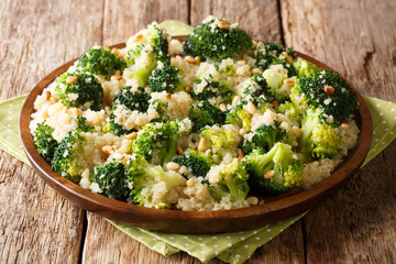 boiled broccoli salad with quinoa and pine nuts closeup on a plate. horizontal