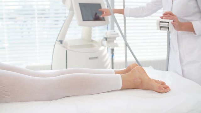 Female patient lies on medical table in LPG suit undergoing procedure to fat and cellulite reduction. Beauty LPG massage therapy gives excellent results. Body weight loss, Anti cellulite.