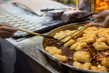 A Man hand is cooking Phongko, Food is a famous in the Asian countries