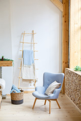 Scandinavian room with blue and white colors. Blue armchair in a white room. Armchair with fabric upholstery