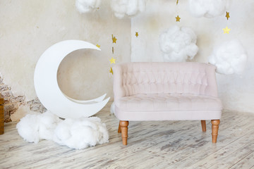 Elegant soft sofa near a concrete wall. Luxury interior of child room in white colors. Decorative...