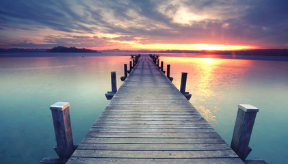 Fototapeta premium Molo na wyspę na jeziorze o wschodzie słońca