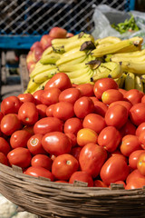 Fresh red tomatoes along with bananas for sale in local market, India. Close up