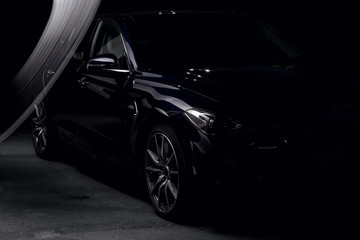 Fototapeta na wymiar Four-door sport coupe. Silhouette of black sports car with headlights