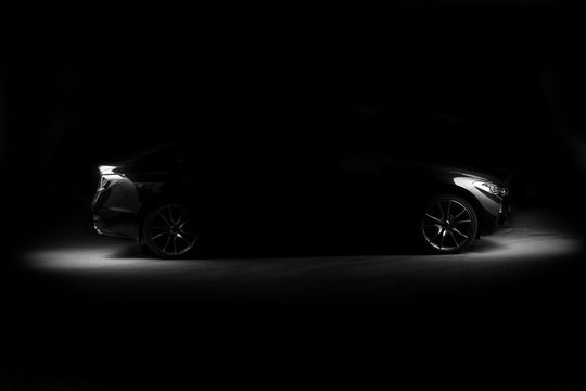 Four-door sport coupe. Silhouette of black sports car with headlights