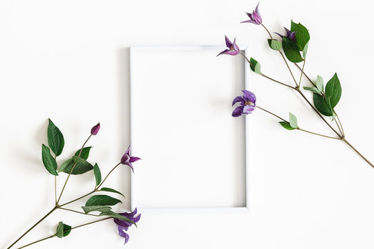 Flowers composition. Purple flowers, photo frame on white background. Spring, easter concept. Flat lay, top view, copy space