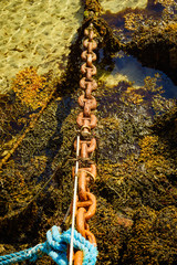 Rusty old metal chain links in port.