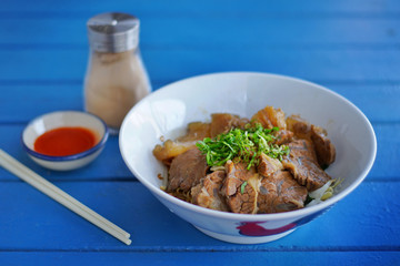 Still life photography of food : Stewed beef with gravy sauce style chinese food on top noodles. Selective and focus. Shooting in studio, Clean food good taste idea concept.