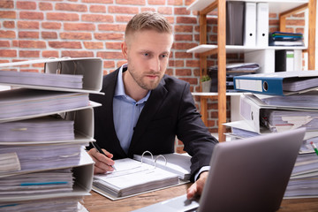 Businessman Working At Desk With Folder Files
