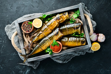 Smoked fish mackerel in a wooden box. Top view. Free space for your text.