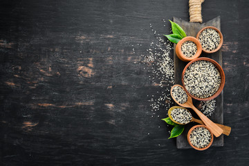 Sesame. Set of black and white sesame seeds. On a black background. Top view. Free copy space.