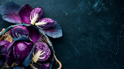 Fresh cabbage. Purple cabbage on a black background. Organic food. Top view. Free space for your text. - obrazy, fototapety, plakaty