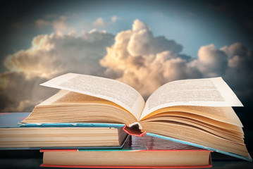 books against the blue sky with clouds
