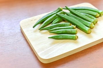 Group of Fresh Okra on Wooden Board