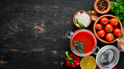 Tomato paste Ketchup with vegetables, homemade. Top view. On a black background. Free space for text.