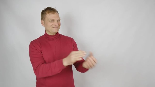 Young handsome man in red sweater posing for the camera. Handsome emotional man. A young man expresses different emotions. Emotions face and handsome hands