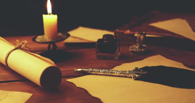 old quill pen on parchment paper in candlelight