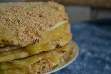 homemade cake withyellow custard.  uneven cake with crumbs on top on the blue background