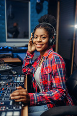 Female musician in headphones in recording studio