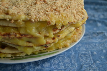 homemade cake withyellow custard.  uneven cake with crumbs on top on the blue background