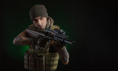 Fototapeta premium The guy in protective clothing and a black mask with a sniper rifle