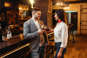 Fototapeta premium Man and woman drinks red wine at bar counter