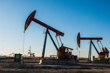 Oil pumps are running in the sunset at the oil field. On the Bohai coast of China.