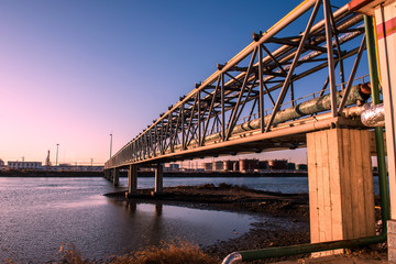 Oilfield pipeline bridge in sunset background