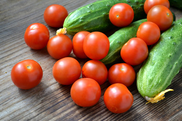 The concept of healthy eating with organic cucumber and cherry tomatoes on wooden table