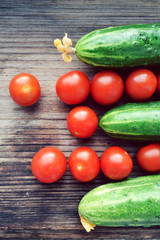 The concept of healthy eating with organic cucumber and cherry tomatoes on wooden table