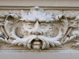snot-nosed  sculpture of a man's head on the facade of an old house