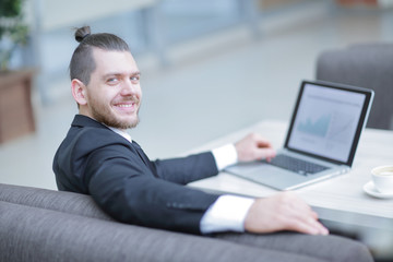 portrait of a smiling businessman sitting at a Desk.