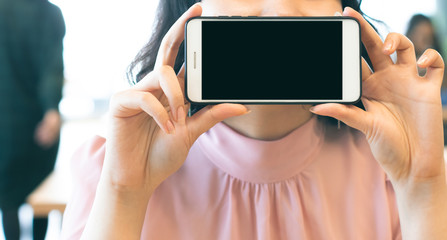 girl with smartphone and black blank space in coffee shop with people on background in social media network concept