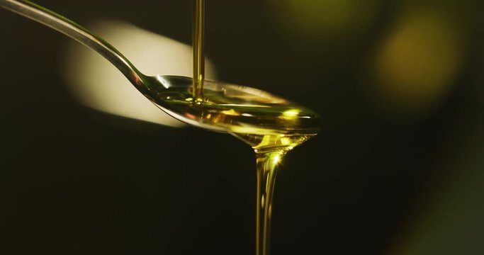 Slow motion macro close up of spoon dosing a biological and ecological hemp plant herbal pharmaceutical cbd oil.