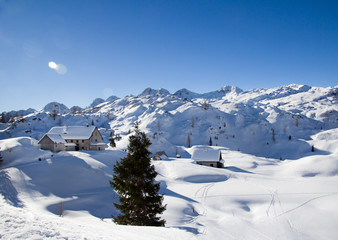  Beautiful alpine landscape with snow-capped mountains and mountain huts covered with fres snow in Julian Alps, Slovenia. There are is snowshoeing and ski touring paradise.