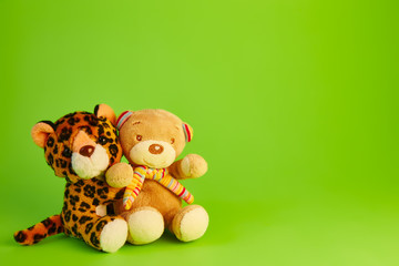 teddy bear; and a toy leopard green background