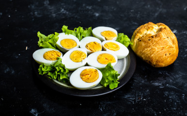 plate with hard-boiled eggs, with the addition of mayonnaise and green leaves of lettuce