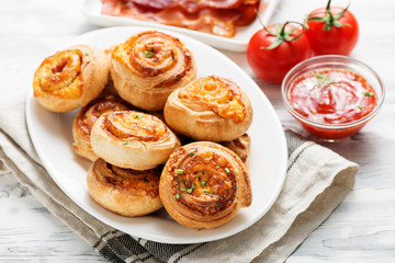 Obraz na płótnie Canvas Rolls of puff pastry with bacon and cheese .