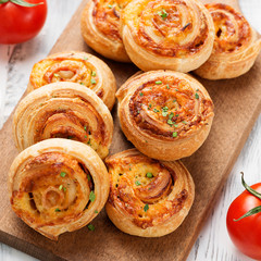 Rolls of puff pastry with bacon and cheese .