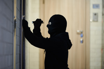 Burglar thief in mask. break-in of an apartment.