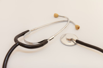 stethoscope with a black tube lies on a white background