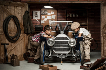 Boys-mechanic with tools in the car in the garage - obrazy, fototapety, plakaty