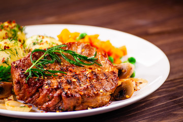 Grilled steak with potatoes and vegetable salad