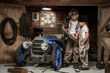 Fototapeta na wymiar Boys-mechanic with tools in the car in the garage