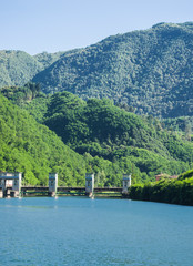 dam on the azure lake in the middle of the green mountains