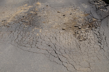 Old worn and cracked asphalt with cracks