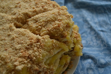 homemade cake withyellow custard.  uneven cake with crumbs on top on the blue background